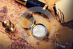 Vintage compass and items on ancient treasure map