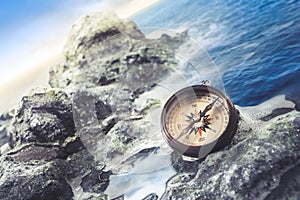 Vintage compass on the sea shore