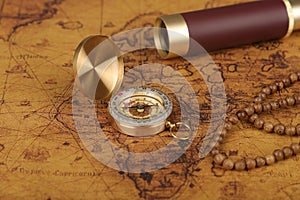 Vintage compass and spyglass on old map - trade and explorer concept