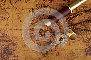 Vintage compass and spyglass on old map - trade and explorer concept