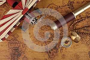 Vintage compass and spyglass on old map - trade and explorer concept