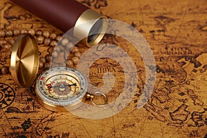 Vintage compass and spyglass on old map - trade and explorer concept