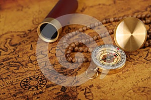 Vintage compass and spyglass on old map - trade and explorer concept