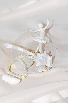 Vintage composition with ballerina, pearls, shellfish, white sea stone and feather