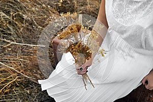 Vintage concept with a young woman holding a bouquet of dry flow