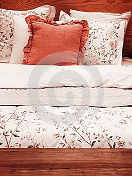 Vintage countryside style bedding with floral pattern on wooden bed in bedroom, interior design