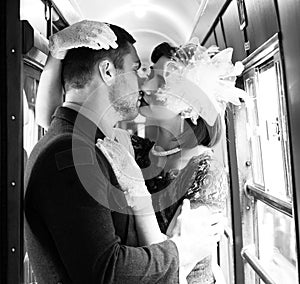 vintage couple kissing and holding each other passionately in corridor of train