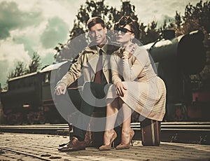 Vintage couple sitting on suitcases