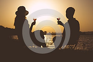 Vintage couples, men and women with glasses of wine in his hand on the river bank in the summer on the nature