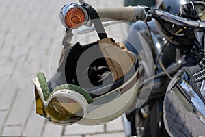 Vintage crash helmet is hanging on the handlebar of a classic oldtimer motorbike