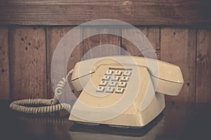 Vintage cream phone on old wooden table