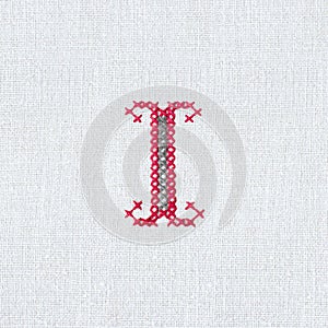 Vintage cross-stitch letter I on linen fabric