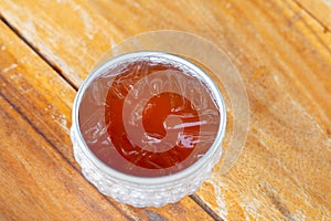 A vintage cup of iced tea on wooden table, summer drink