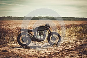 The vintage custom cafe racer in a field