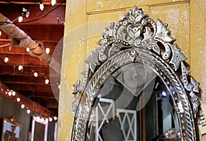 Vintage cut glass Venetian mirror on an old yellow wooden door