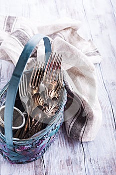 Vintage cutlery in old blue wicker basket