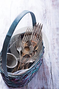 Vintage cutlery in old blue wicker basket