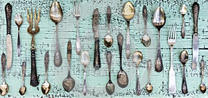 Vintage cutlery - spoons, forks and knives on an old wooden background