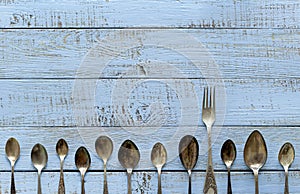 Vintage cutlery - spoons, forks and knives on an old wooden background