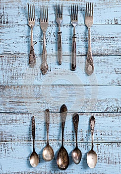 Vintage cutlery - spoons, forks and knives on an old wooden background