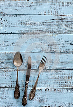 Vintage cutlery - spoons, forks and knives on an old wooden background