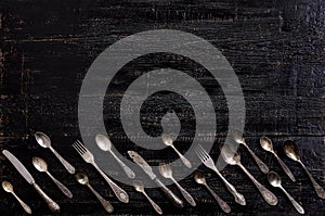 Vintage cutlery - spoons, forks and knives on an old wooden background