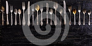 Vintage cutlery - spoons, forks and knives on an old wooden background