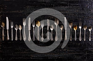 Vintage cutlery - spoons, forks and knives on an old wooden background