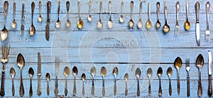 Vintage cutlery - spoons, forks and knives on an old wooden background