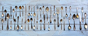 Vintage cutlery - spoons, forks and knives on an old wooden background