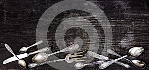 Vintage cutlery - spoons, forks and knives on an old wooden background