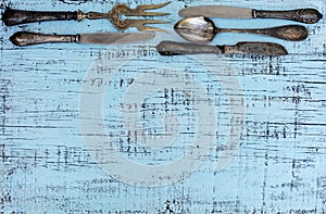 Vintage cutlery - spoons, forks and knives on an old wooden background