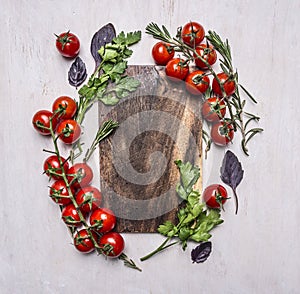 Vintage cutting board with herbs and vegetables on wooden rustic background top view close up place text,frame