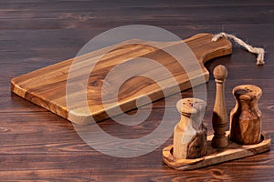 vintage cutting board with salt pepper shaker on old wooden background, close-up