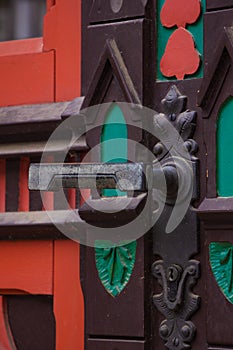 Vintage dark red antique double door in Paris. Round handle on aged wood surface. vertical orientation