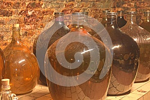 Vintage demijohns in a traditional wine cellar. Demijohn wine bottles