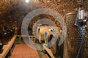 Vintage demijohns in a traditional wine cellar. Demijohn wine bottles and wooden wine barrels