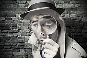 Vintage detective looking through a magnifier