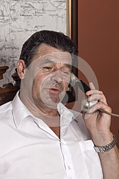 Vintage director, forties, man talking on a corded phone