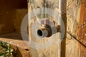 Vintage Dirty Plastic Water Faucet with PVC Valve - Old Concrete Texture -Sunny Warm Day in Home Garden