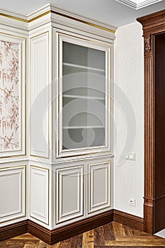 Vintage display case with glass door near doorway in light room