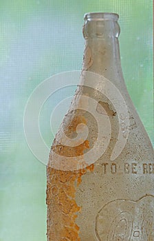 Vintage Distressed Glass Bottle with Brown Stains and Lettering