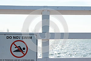 Vintage `do not swim` picture signage at a seaside beach salt water pool on a hot summer day