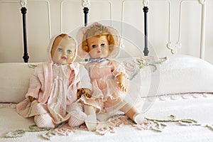 Vintage Dolls on Chanille Bedspread on Iron Bed