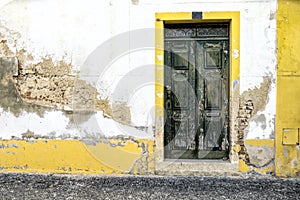 A vintage door on the facade of an old stone wall.