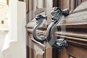 Vintage door handles close up. Old wooden door with beautiful retro door knobs