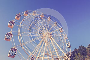 Vintage edit Ferris wheel on the background of the blue sky. Amusement park retro carnival  no people. Carnival stock photography