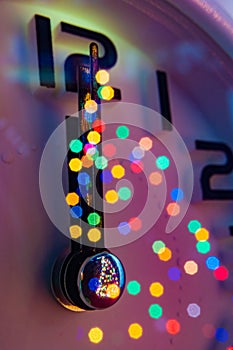 Vintage effect with close up Christmas Composition with alarm clock and reflection of bokeh lights from clock glass. Pine tree in