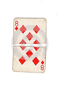 A vintage eight of diamonds playing card torn in half.