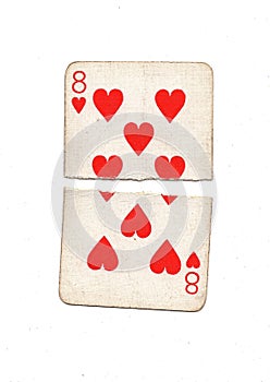A vintage eight of hearts playing card torn in half.